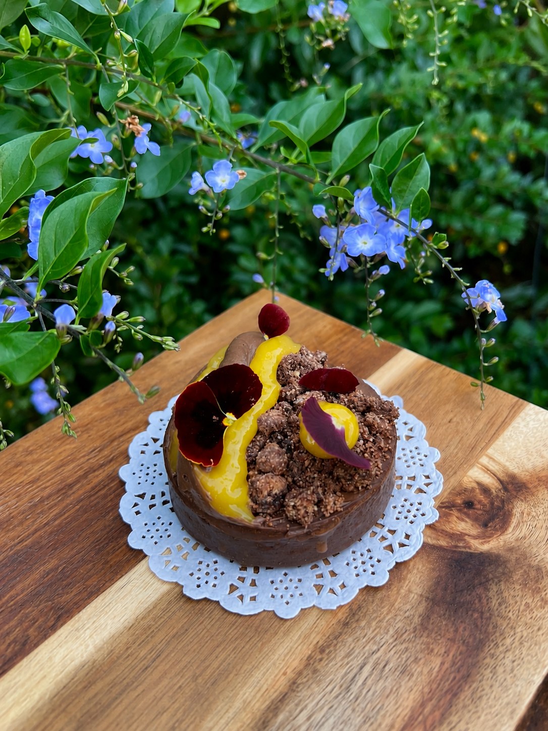 A chocolate crémeux topped with citrus curd, chocolate crumble and a viola flower