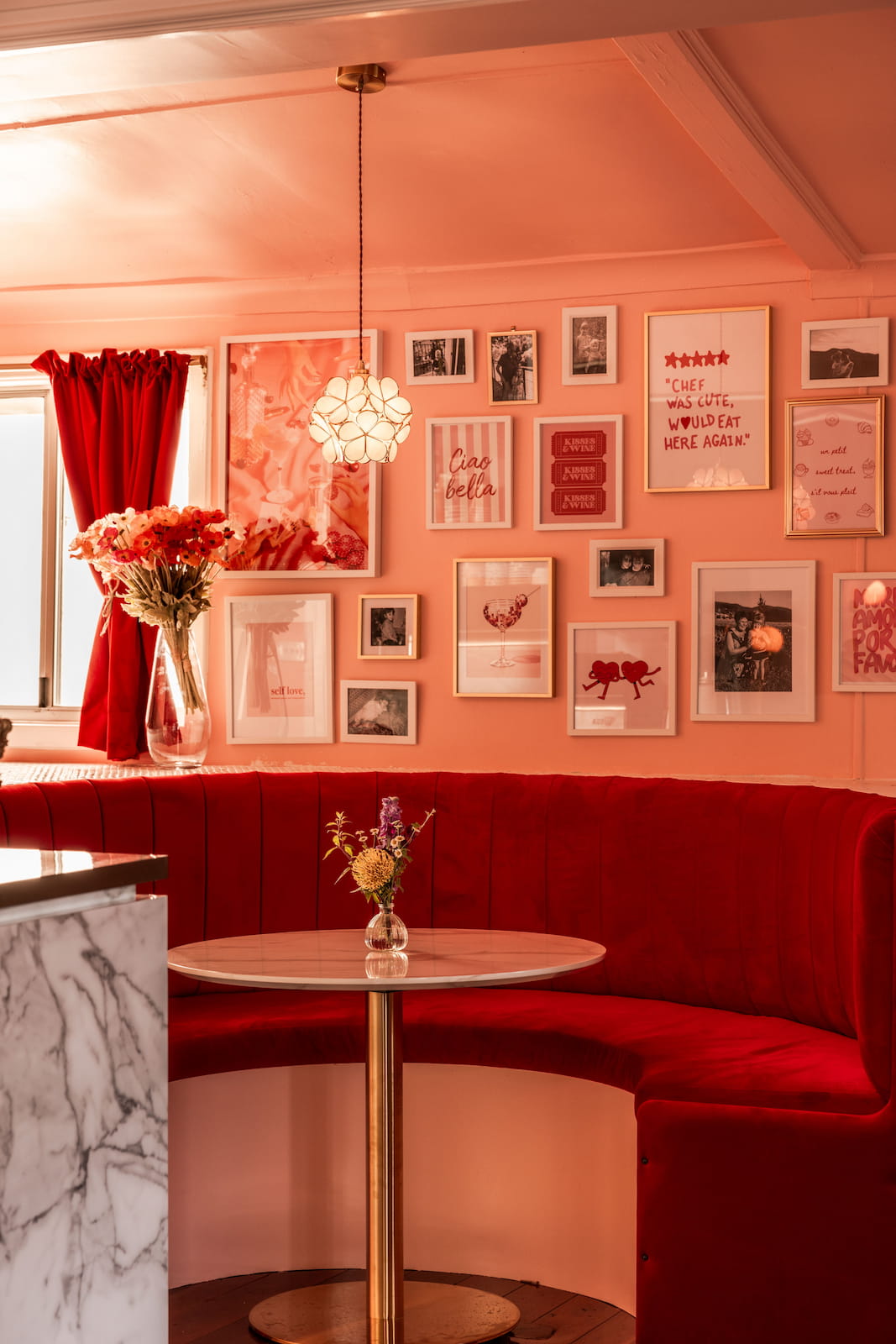 A wall of framed pictures inside La Pâtisserie Cottage